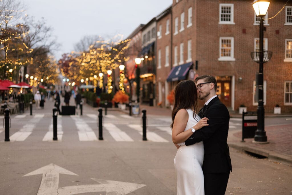 wide shot of newlyweds holding each other close 
during an unplanned first dance on King Street 
in Old Town Alexandria Virginia — Kelly Wineinger 
Creative elopement photographer