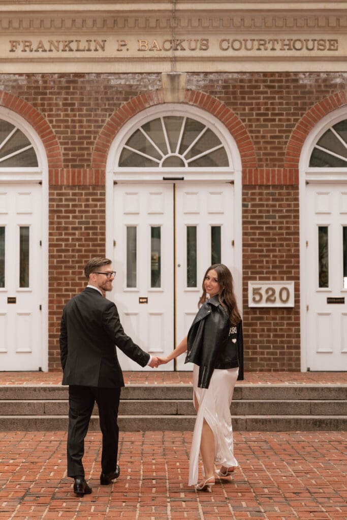 Bride in "Just Married" leather jacket laughing with her new husband at the historic courthouse in Old Town Alexandria — Kelly Wineinger Creative