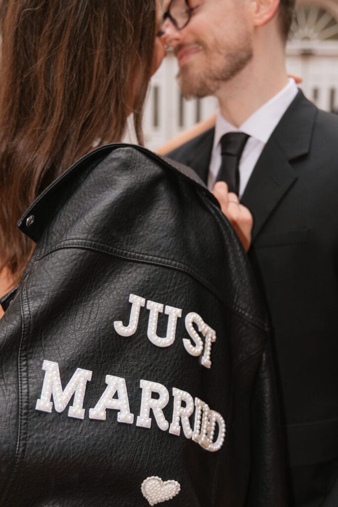 Close up detail of bride's "Just Married" leather jacket on the cobblestone streets of Old Town Alexandria, Virginia — intimate elopement photography by Kelly Wineinger Creative
