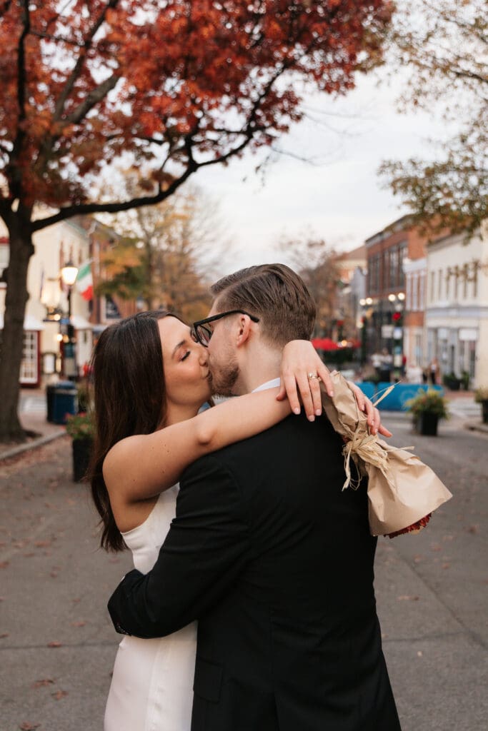 Newlywed couple sharing a spontaneous first dance 
in the middle of King Street in Old Town Alexandria 
to a street musician playing on the sidewalk during 
their November elopement — Kelly Wineinger Creative