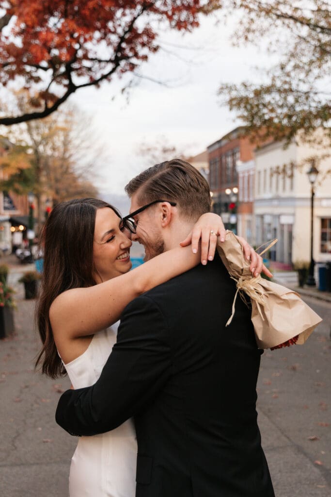 Bride and groom dancing together on King Street 
in Old Town Alexandria Virginia while a street 
performer plays music nearby — intimate elopement 
photography by Kelly Wineinger Creative