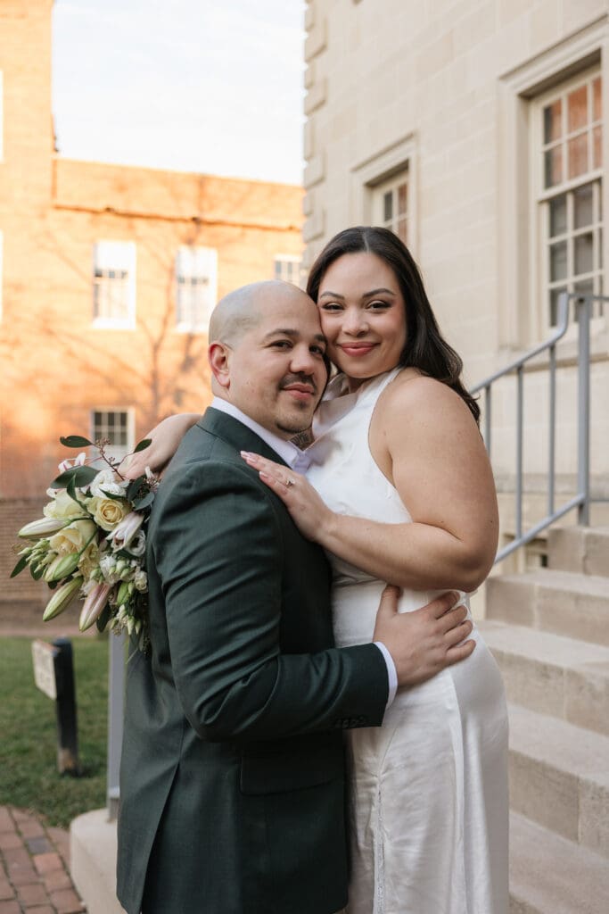 couple poses for romantic couples portraits in front of the historic Carlyle House in Old Town Alexandria