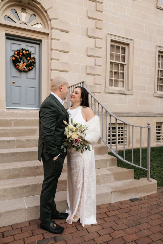 Couple shares a sweet moment in front of the historic Carlyle House in Old Town Alexandria