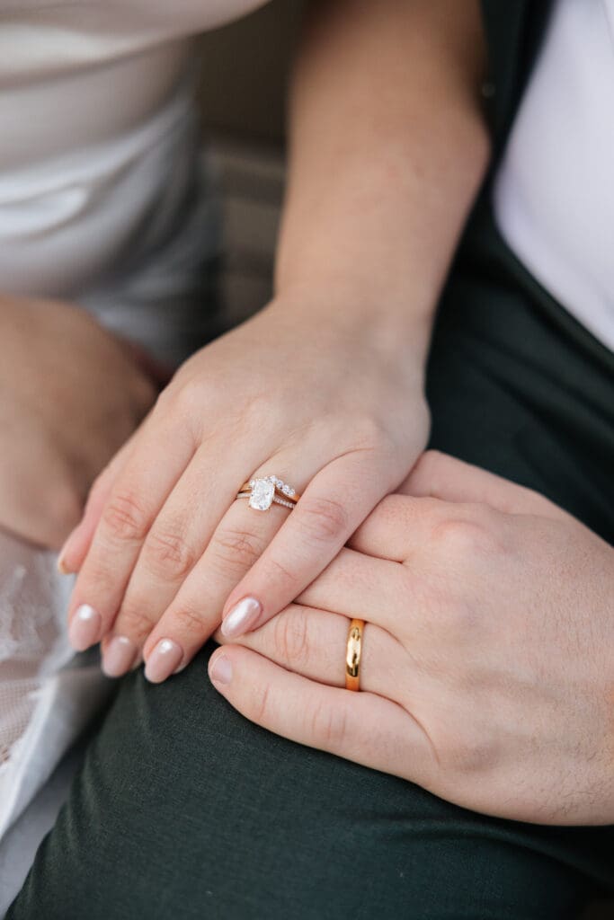 couple holds hands displaying their wedding rings