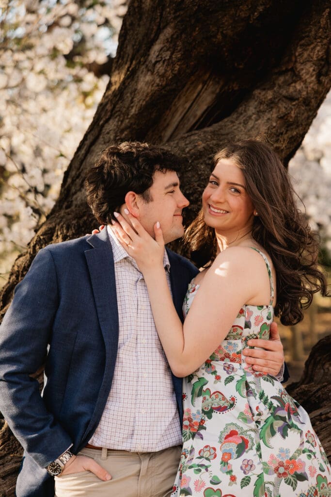 man gazes at his fiancee during a sweet engagement photoshoot in Washington DC during cherry blossom season