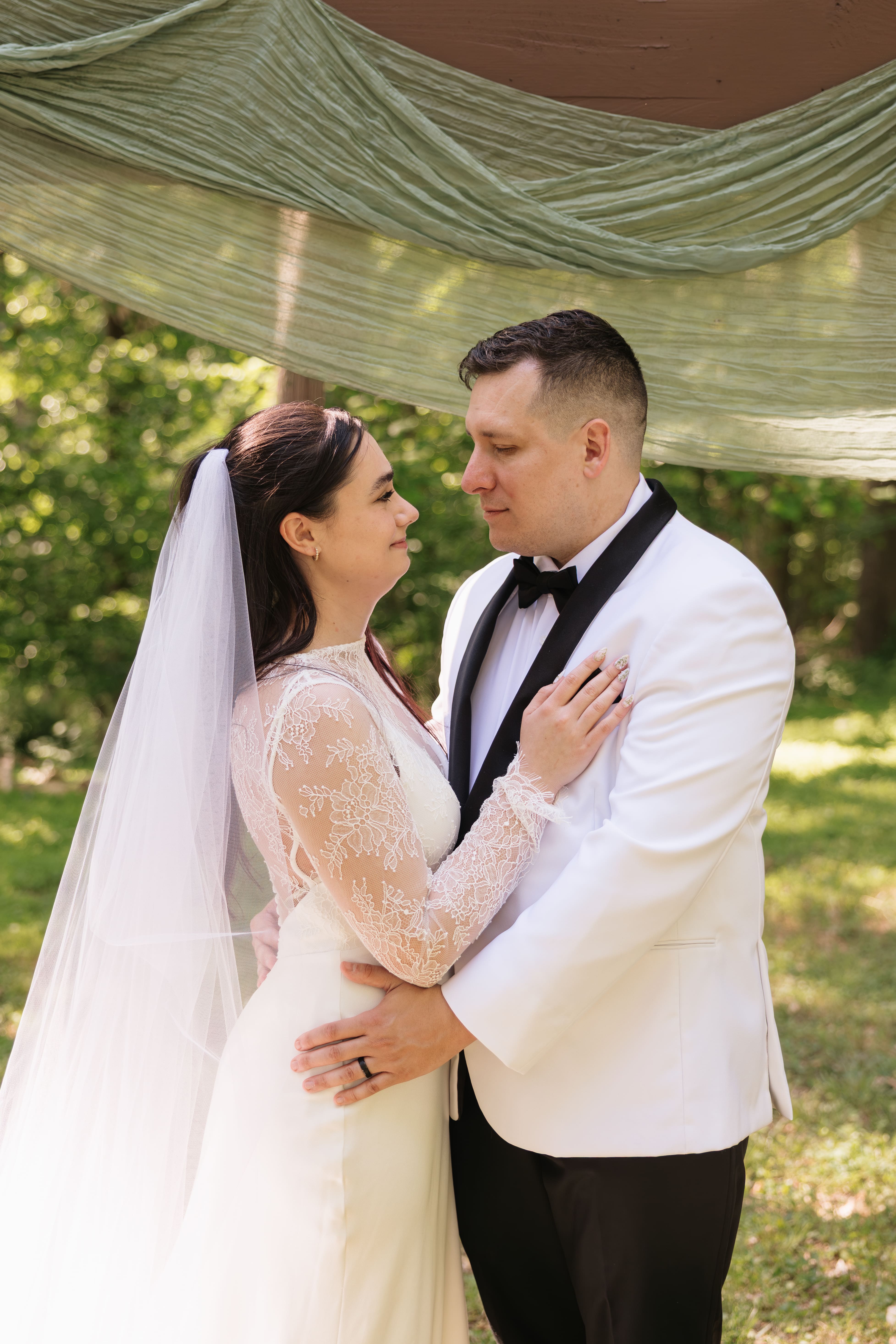 couples smiles at each other during portraits after their Northern Virginia wedding ceremony