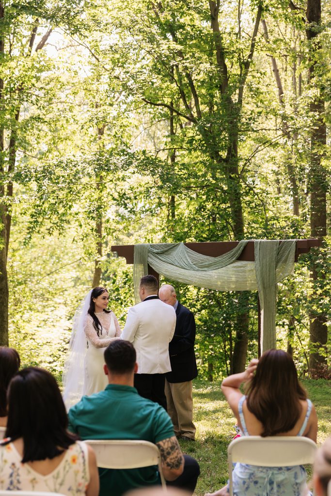 couple stands at the altar during their backyard wedding ceremony in Northern VA