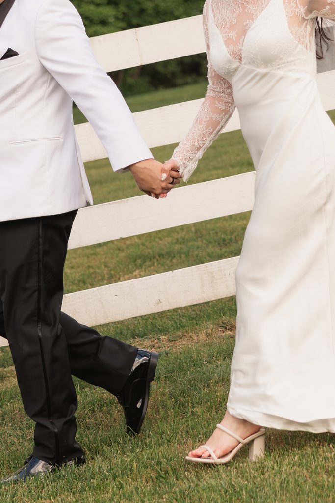couple holds hands and walks together during bridal portraits