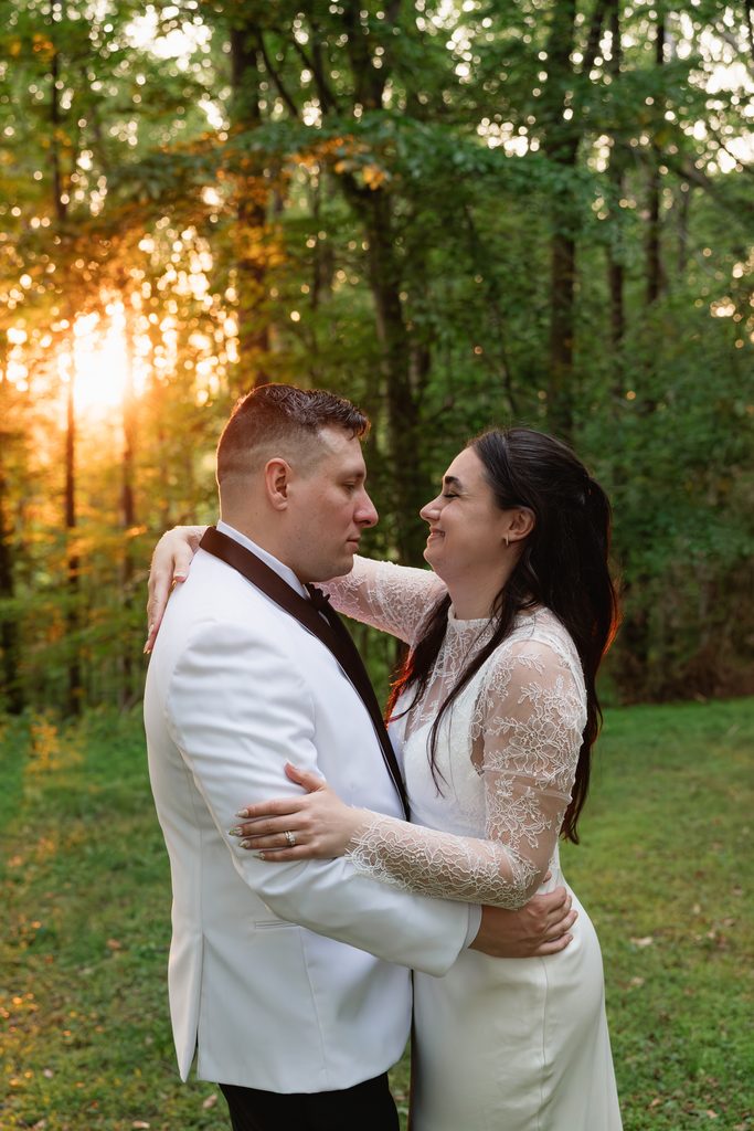 couple smiles for a candid wedding portrait during golden hour