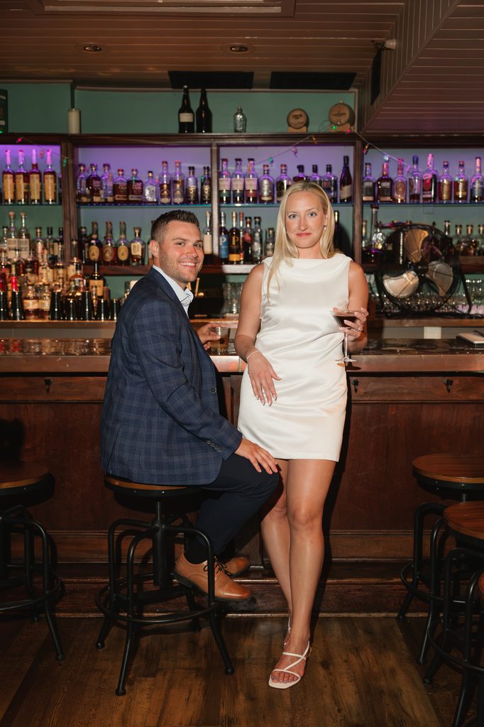 couple poses for engagement photos in an Old Town Alexandria speakeasy
