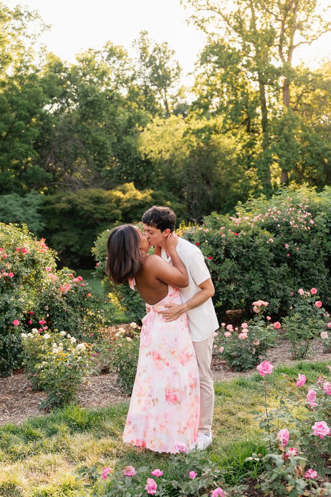 couple shares a kiss during a fun engagement photoshoot at Bon Air Park