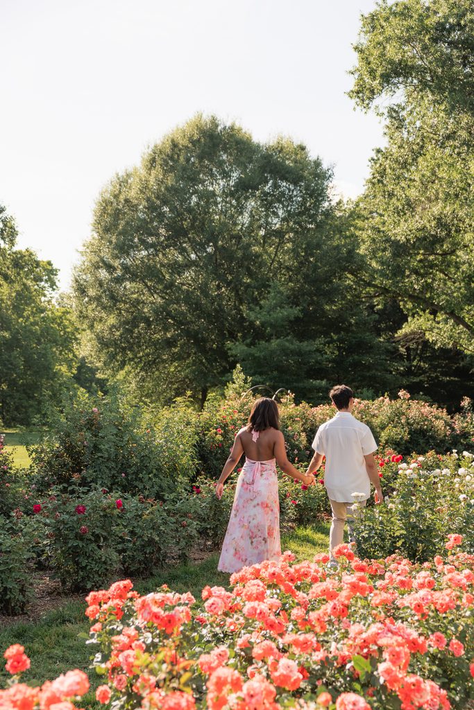 couple walks through the gardens at Bon Air Park in Arlington during their engagement photos