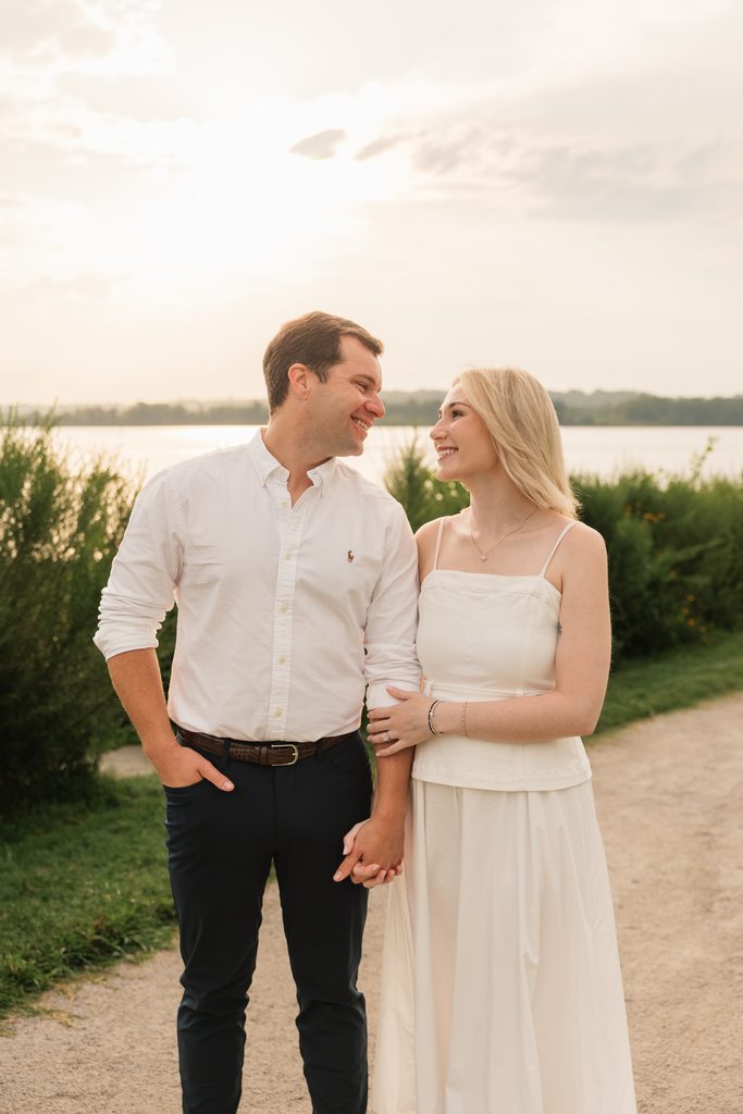 couples smiles at each other during sunrise engagement photos in Northern VA