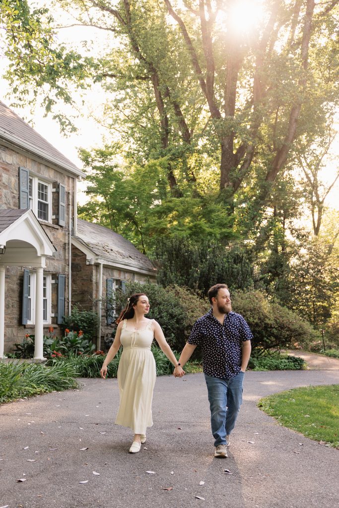 couple walks in front of a historic home during this engagement photoshoot in the DMV