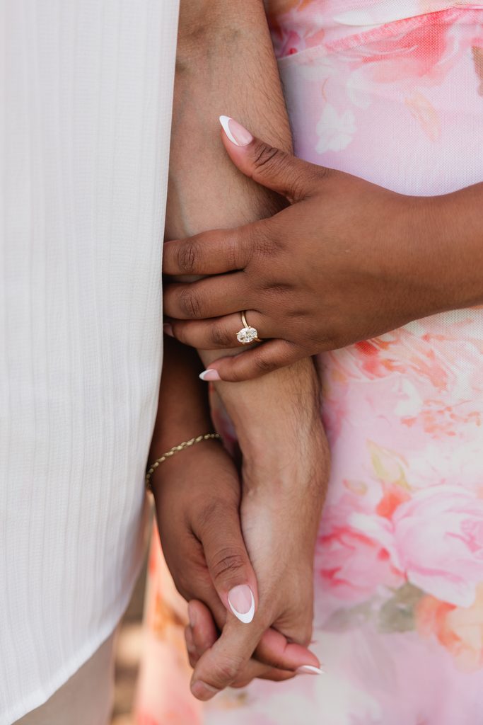 bride shows off her engagement ring in this detail shot of the couples hands during their engagement photoshoot