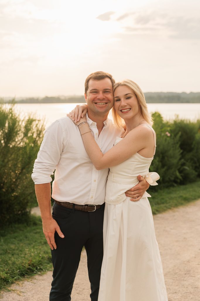 couples smiles at the camera during golden hour engagement photos in Northern Virginia